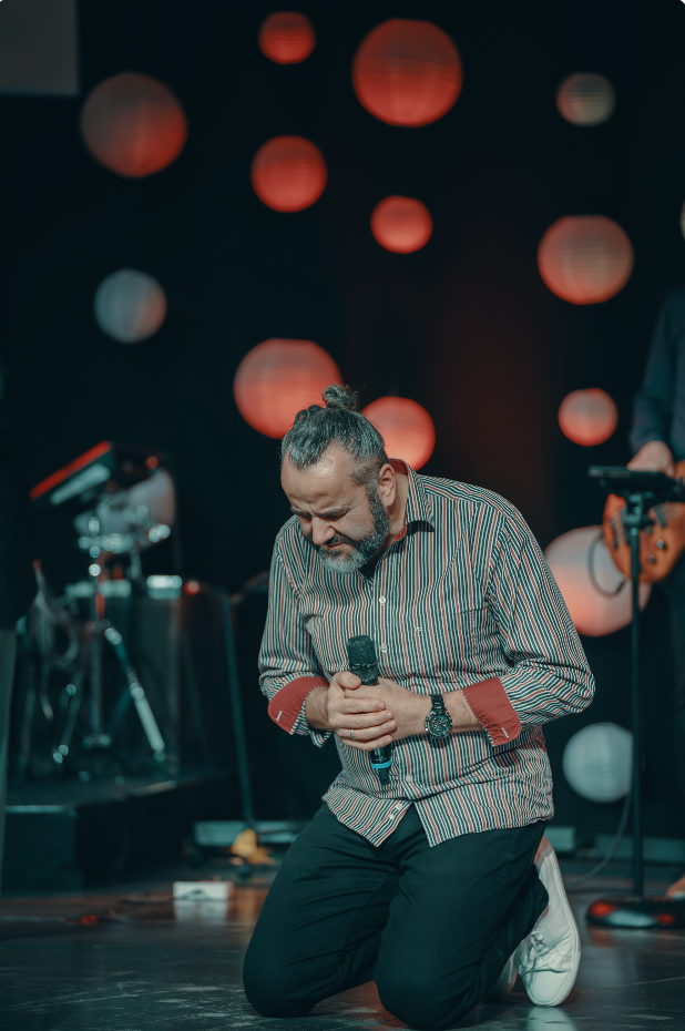 Matthias kneeling in prayer on stage